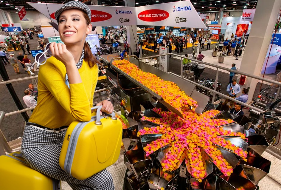 Heat and Control Booth at Pack Expo Pack Expo Attendee at Heat and Control Exhibit Showcasing Crossfeeder and Ishida Weigher